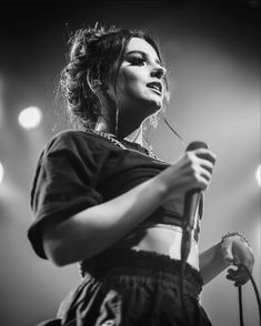 a woman holding a microphone in her right hand