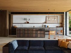 a living room filled with furniture next to a kitchen