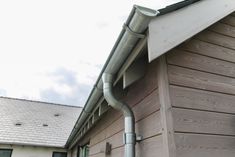 a gutter hose attached to the side of a house