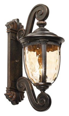 an old fashioned wall light with a glass shade on the front and side paneling