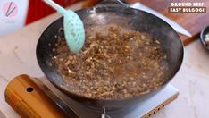 a frying pan filled with food sitting on top of a stove next to a spatula