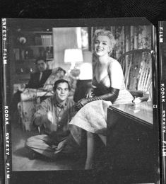 an old black and white photo of a woman sitting on the floor next to a man