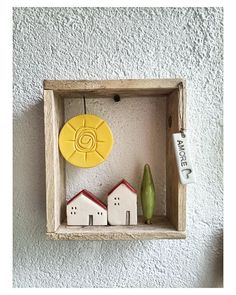 a wooden box with some small houses and a yellow object on it's side