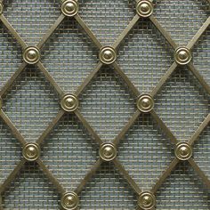 an up close view of a metal mesh wall with circles and rivets on it