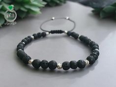 Elevate your style with our handcrafted unisex bracelet featuring 4mm Lava Stone beads, paired with 3mm Diamond Cut silver for a luxurious finish. The adjustable design ensures a comfortable fit, making it perfect for any outfit. Properties of Lava Stone Combined with Silver: Lava Stone has: Grounding: Stabilizes energy. Protection: Repels negativity. Energy: Boosts strength. Porous: Absorbs oils. With silver, Lava Stone can: Promote inner peace and intuition. Aid in energy cleansing. Overall, t Handmade Black Sterling Silver Braided Bracelet, Silver Beaded Bracelets With 8mm Lava Stone Beads, Silver Lava Stone Beaded Bracelets With 8mm Beads, Handmade Adjustable Lava Stone Beaded Bracelets, Minimalist Black Sterling Silver Beaded Bracelets, Minimalist Adjustable Lava Stone Jewelry, Adjustable Silver Lava Stone Bracelets, Adjustable Sterling Silver Beaded Bracelets With 8mm Beads, Unisex Bracelets