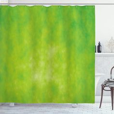 a bathroom with a green shower curtain in the corner and a chair next to it