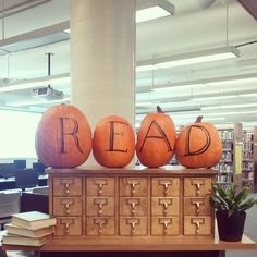 three pumpkins with the word read spelled on them sitting on top of a filing cabinet