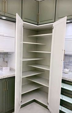 an empty pantry in a kitchen with green cabinets and marble counter tops on the floor