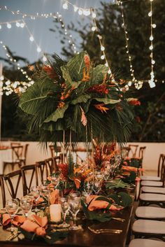 the table is set with candles, flowers and greenery for an outdoor wedding reception