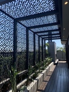 an outdoor area with wooden floors, plants and trelliss on the roof top