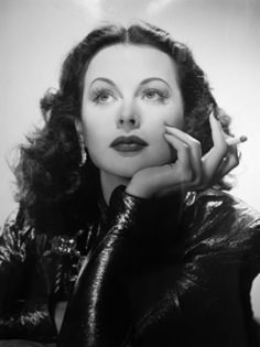 an old black and white photo of a woman with her hand on her chin looking up