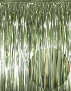 a circular mirror is in front of a metallic curtain that has vertical lines on it