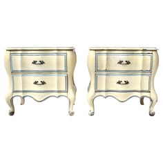 two white nightstands with blue trim on each drawer and one has an open drawer