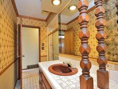 a bathroom with a marble counter top and wooden columns