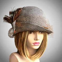 This beautiful ladies cloche is made from fur felt, and hand draped over an antique hat block, and embellished with french veiling, and feathers, which may vary depending on availability.     Please indicate your head size measurement when ordering (measure your head horizontally just above your eyebrows). When you receive your hat, there will be a small ribbon inside to fine-tune the fit, and a hat box for safe storage. Note: Colors will vary depending on your monitor and there will also be some variations due to dye lots. I personally create each hat one at a time, and no two are ever exactly the same.  My hats are 100% handmade for you, using traditional Millinery techniques and the highest quality fabrics and details.  I frequently trim  my hats with one-of-a-kind details, i.e. vintage Elegant Gray Felt Hat With Short Brim, Elegant Gray Brimmed Felt Hat, Elegant Fur Felt Cloche Hat For Kentucky Derby, Elegant Gray Felt Hat With Curved Brim, Evening Top Hat With Feathers And Short Brim, Gatsby Style Cloche Hat For Kentucky Derby, Evening Mini Hat With Feathers And Short Brim, Evening Hats With Ostrich Feather Trim, Elegant Feathered Hat For Winter