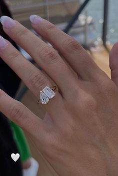 a woman's hand with an engagement ring on it