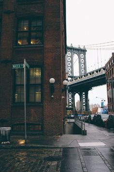 an old brick building with a bridge in the background