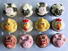 twelve cupcakes with farm animals and pigs on them are arranged in a plastic tray