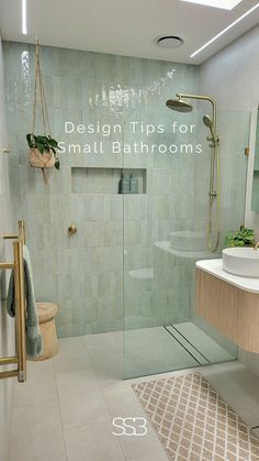 a bathroom with a glass shower door and tiled walls, along with a rug on the floor