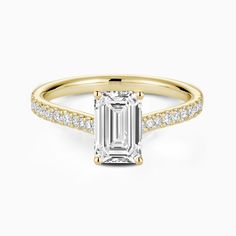 an emerald cut engagement ring with diamonds on the band