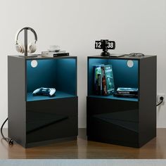 two black nightstands with books and headphones on each side, one is open