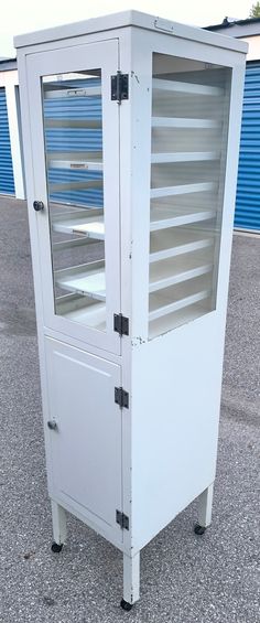 an empty white cabinet sitting on top of a parking lot