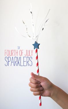 a hand holding a red, white and blue sparkler with the words fourth of july on it