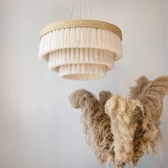 a chandelier hanging from the ceiling next to some fluffy sheeps in front of it