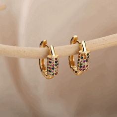 Embrace life’s colorful moments with our Rainbow Gem Huggie Earrings. These dainty gold or silver loops, dotted with a spectrum of sparkling gems, are designed to hug your ears with a gentle, comfortable fit. Perfect for adding a subtle shimmer to your everyday look or a pop of color for a special occasion. Let these earrings remind you of the beauty in every day. Christmas Party Jewelry, Colorful Stud Earrings, Gold Color Ring, Earrings Stone, 18k Gold Earrings, Purple Necklace, Couple Jewelry, Platinum Metal, Earring Type