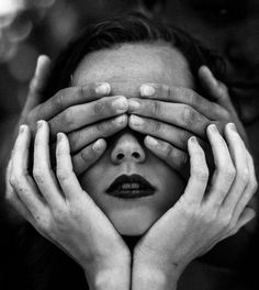 a woman covering her eyes with both hands