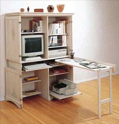 a desk with a computer on top of it in front of a book shelf filled with books