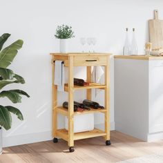 a wooden shelf with shoes on it next to a potted plant