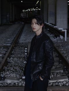 a man standing in front of train tracks