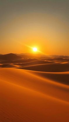 the sun is setting over sand dunes in the desert