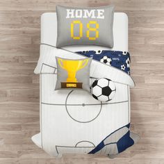 a bed with a soccer themed comforter and pillows