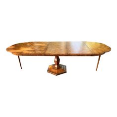 an oval wooden table with two pedestals on each side and one leg in the middle