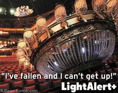 a chandelier hanging from the ceiling in an auditorium with words above it that read, i've fallen and i can't get up light alert