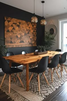 a dining room table with black chairs and a large painting on the wall behind it