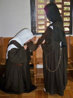 two women dressed in nun costumes sitting at a table