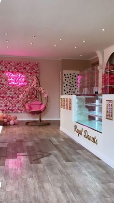 a pink chair sitting in front of a wall covered with flowers and hearts on it's side