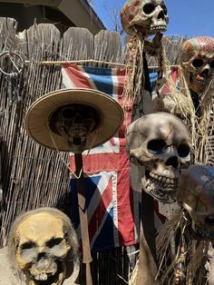 three skeletons wearing hats and masks in front of a fence with a british flag on it