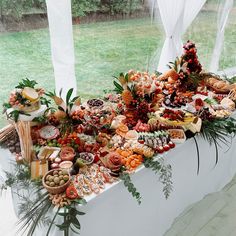 a table covered in lots of food sitting on top of a wooden floor next to a window