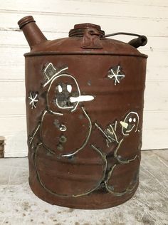 an old fashioned metal pot with a snowman painted on it