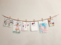 some pictures hanging on a clothes line with clothes pins