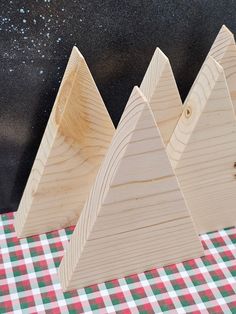 three wooden mountains sitting on top of a checkered table cloth