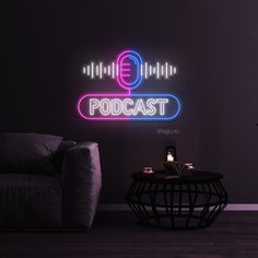 a living room with a couch, chair and neon sign on the wall that says podcast