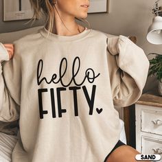 Looking for the perfect 50th birthday gift? Look no further than this trendy Hello 50 sweatshirt and shirt. Not only is it a great gift for someone turning 50, but it also makes for a fantastic party shirt or t-shirt! Whether you're celebrating with your friends or family, this shirt is sure to bring plenty of laughs and happy memories. So don't wait any longer - order your own 50th birthday shirt today! **PLEASE NOTE THERE ARE VARIOUS STYLES AND SIZES AVAILABLE IN LISTING SO PLEASE MAKE SURE YO 50th Birthday Gift Ideas For Women, 50th Birthday Tshirts, Hello 50, Turning 50, Little Sister Gifts, 50th Birthday Shirts, 50 And Fabulous, Fabulous Birthday, Birthday Tshirts