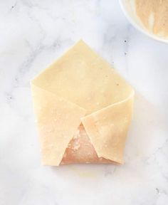 a piece of cheese sitting on top of a counter next to a bowl and spoon