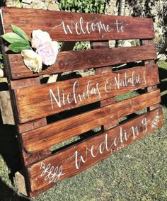 a wooden sign that says welcome to nicholas and martha, with flowers on the back