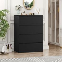 a black chest of drawers in a white room